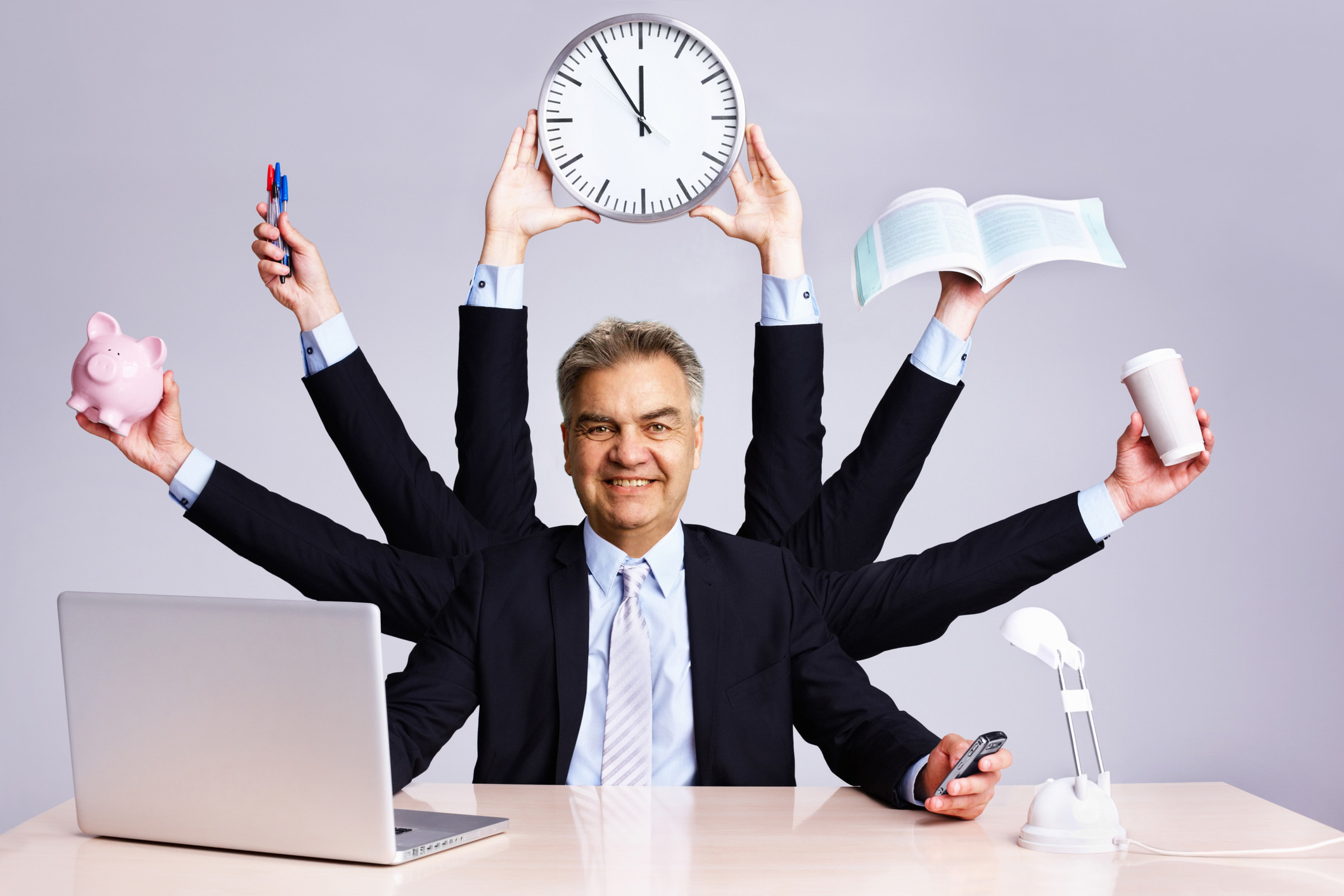 Confident business man multitasking at desk